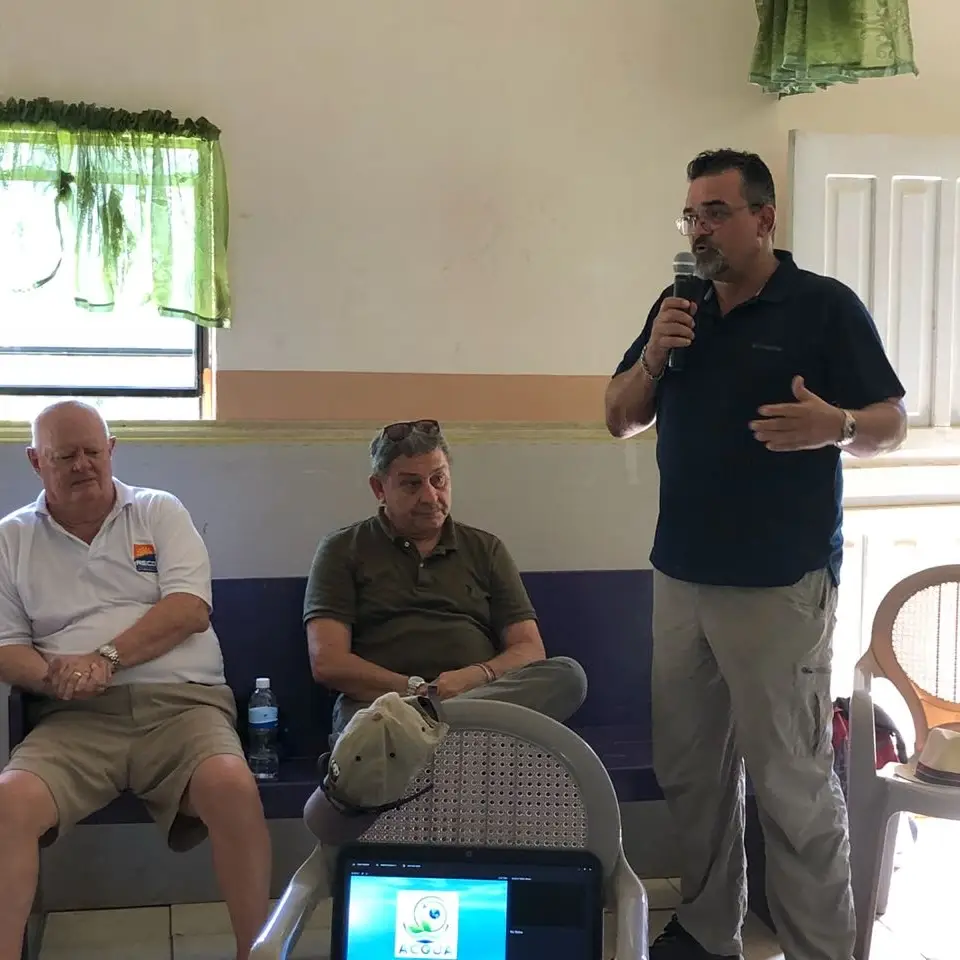 M J Harper giving a talk in Helene, holding a microphone